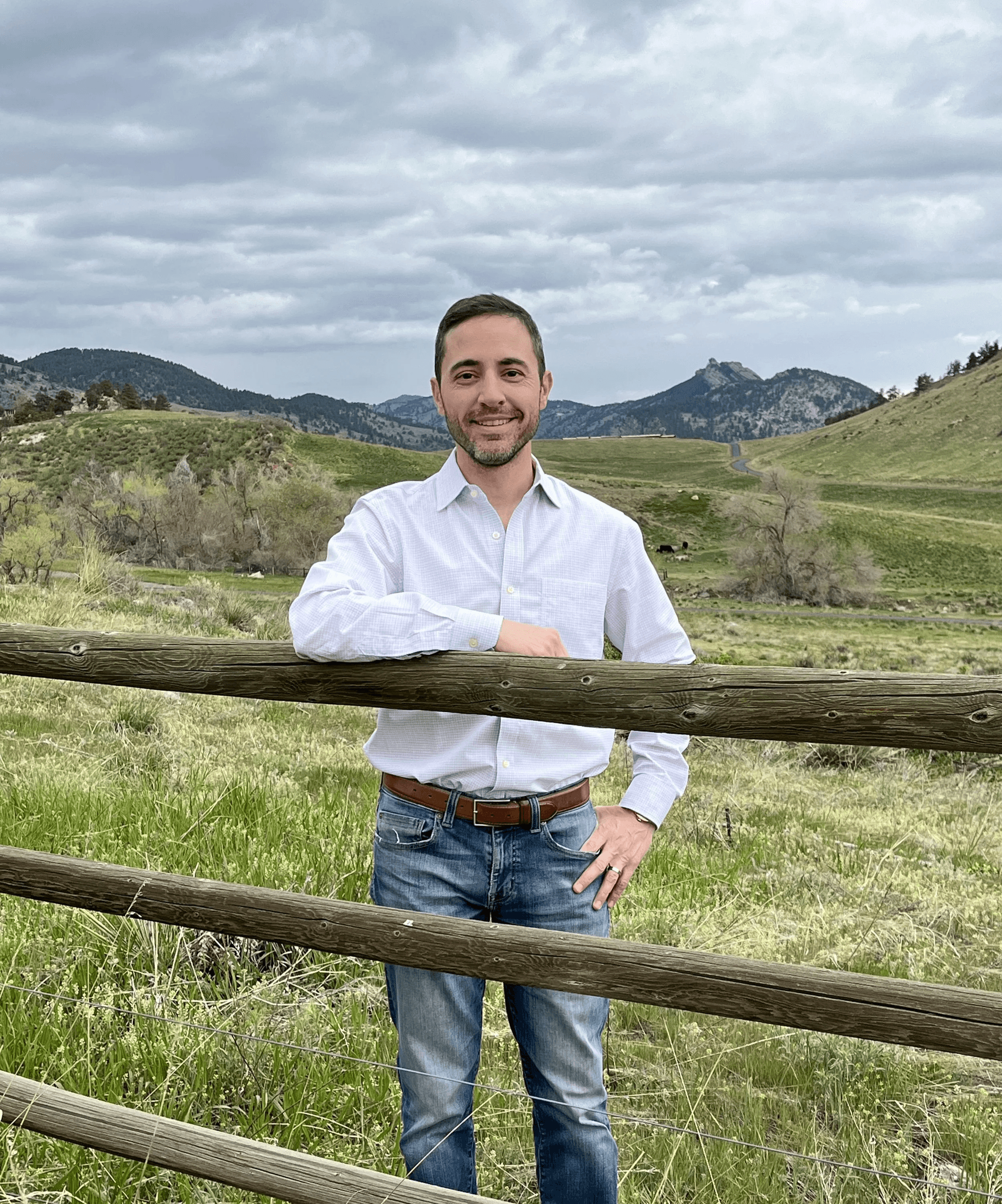 Man standing by a wooden fence in a grassy field-freedlight-performance